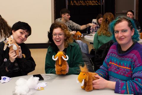 Three students pose with stuffed animals.